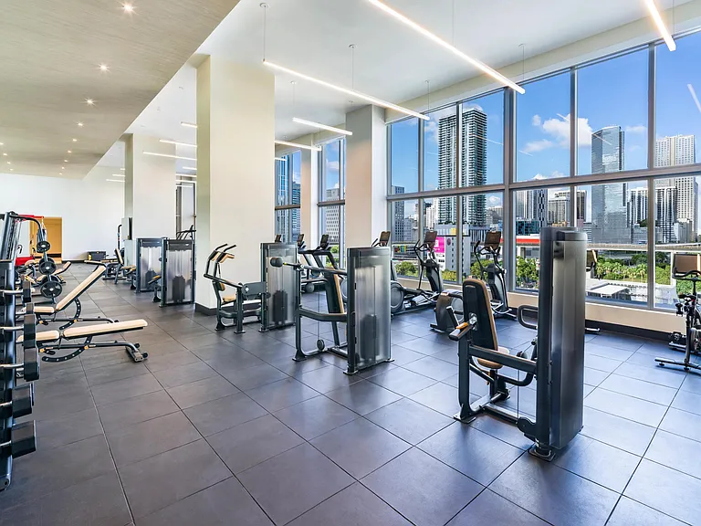 Elevate your workout at Modera Riverside's expansive fitness studio with inspiring Miami skyline views.