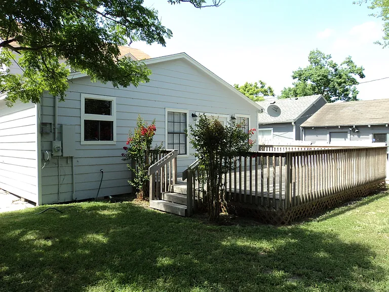 The deck is surrounded by crepe myrtles. Large backyard.