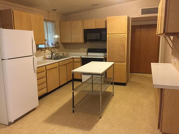 Huge kitchen with an island and storage rack. It is great fo
