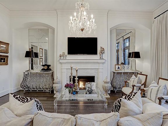 The gorgeous mantle with Carrara marble surround is flanked by art niches which give the living room a regal feel. Symmetry at its finest.