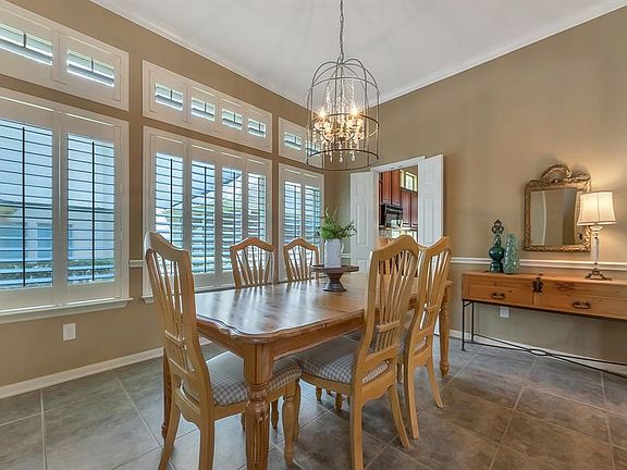 Large Dining Room is centered with an on-trend light fixture and features a wall of windows. Entry to the Kitchen is just through the doors to the left.