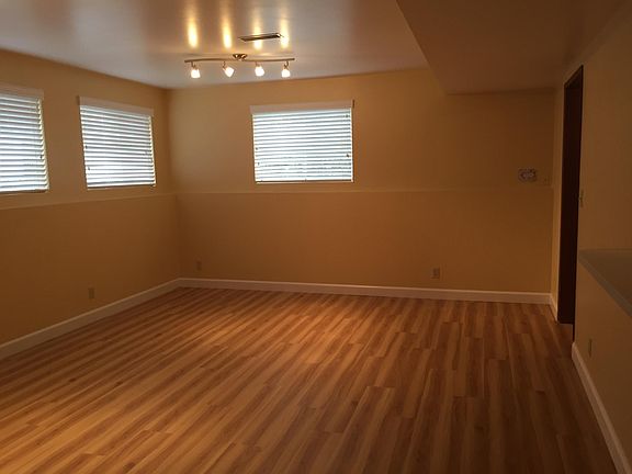 Combination living and dining room. Gorgeous hardwood-like floors, contemporary lighting, and tons of natural light from multiple windows (all with new blinds).