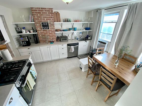 eat in kitchen, dishwasher, exposed brick, open shelving