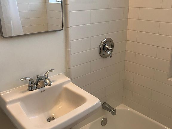 Bathroom with Tub and Shower Combination. Bathroom recently retiled including floors and walls. Tub reglazed.