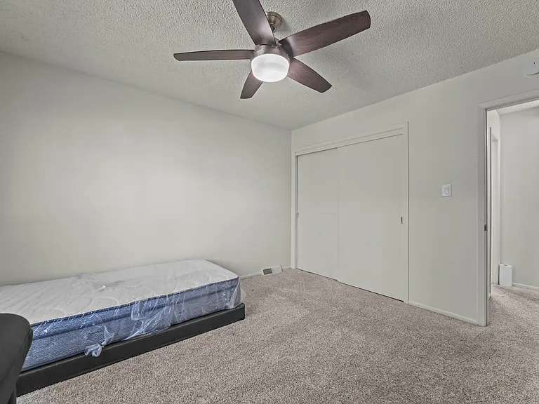 Bright second bedroom featuring a large window for natural light and a spacious closet.