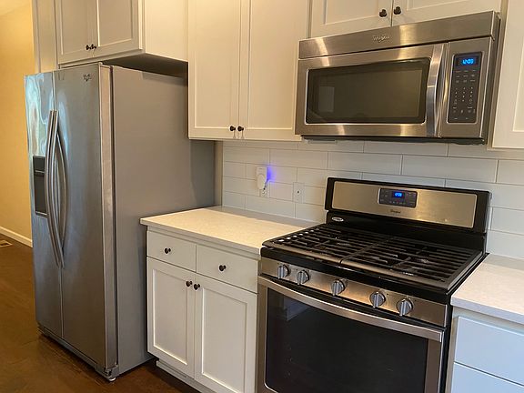 Well equipped kitchen. Stainless appliances, quartz countertop and tile backsplash.