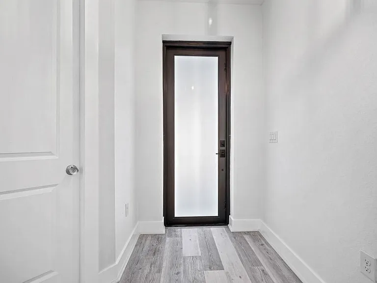 Front Entrance Door, high end laminate flooring through out this home. 8 foot doors with beautiful finishes