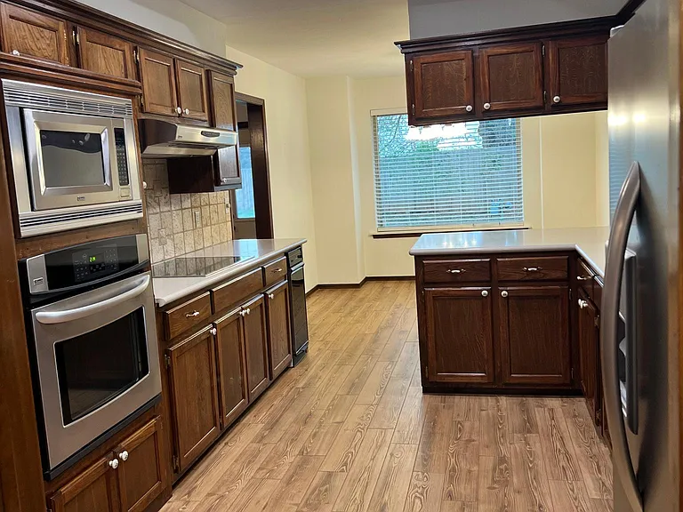 View of kitchen and dining room. Refrigerator