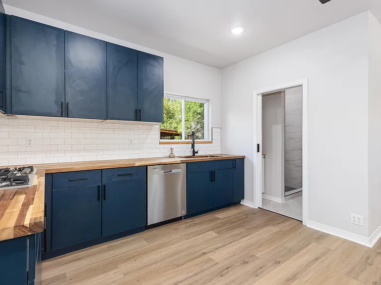 Inviting and warm butcher block counters. The adjacent large bathroom has a pocket door for optimal privacy and space efficiency.