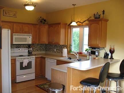 Kitchen
						:
						Glass mosaic tile backsplash, oak cabinets, glass top stove and breakfast bar