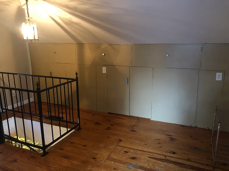 Large landing at top of spiral staircase - easily fits a desk and has lots of storage against wall (pic taken before the second mini-split was installed)