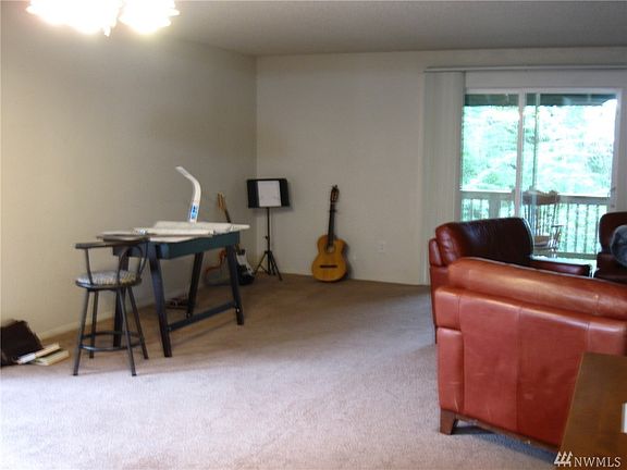 19409:  Very large Living Room features sliders to the private deck overlooking the verdant greenery.