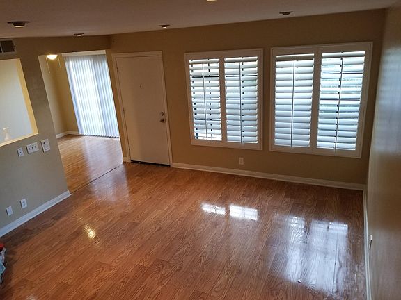1st floor living room with wood laminate floors and plantation shutters
