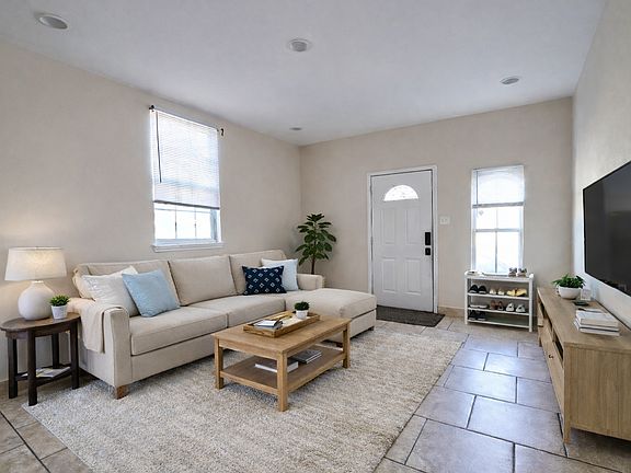 Open Living Area: Spacious open living area with tile flooring throughout for easy maintenance