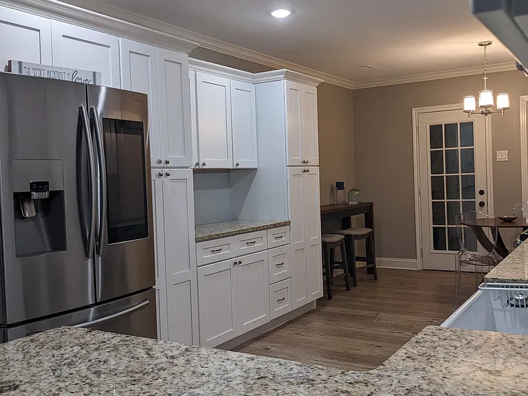 Modern kitchen with farmhouse sink, plenty of seating and counter space. Samsung refrigerator with Alexa