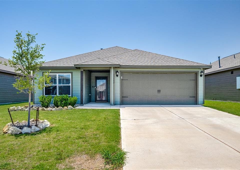 Single story home featuring roof with shingles, a front lawn, driveway, and a garage