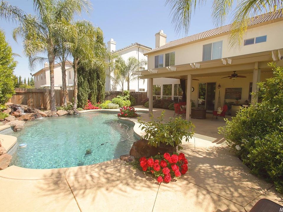 The stunning backyard is an oasis of relaxation. Complete with a dive rock and rock waterfall.