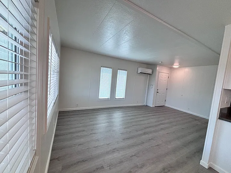 The living room welcomes you with an open, inviting layout designed for both comfort and functionality. Large windows allow natural light to fill the space, creating a bright and airy atmosphere.