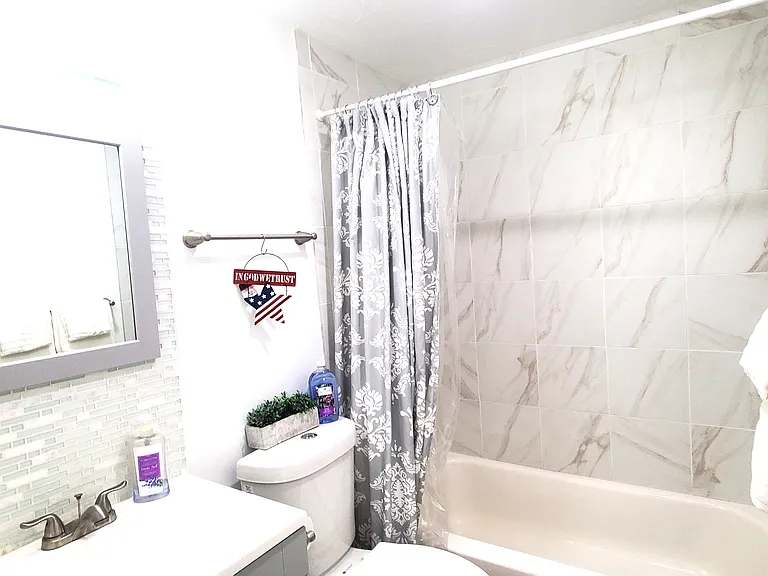 Close-up of the stylish bathroom featuring a beautiful glass tile backsplash. The clean, modern design and thoughtful details create a spa-like atmosphere.
