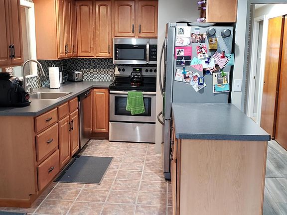 Kitchen with new appliances, lights and tile backsplash.