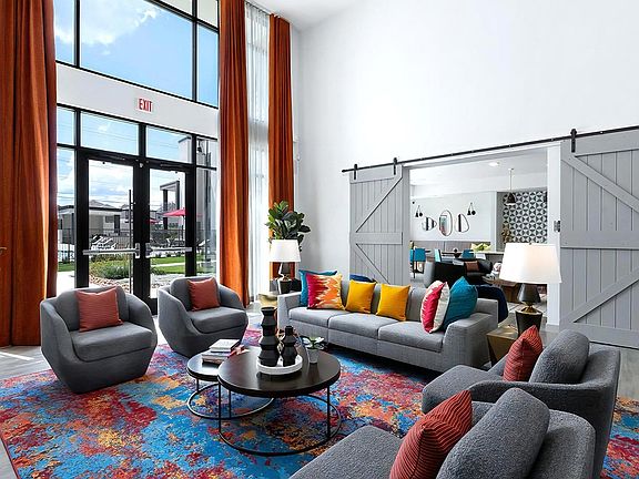 Colorful Resident Lounge Featuring High Ceilings and Floor-to-Ceiling Windows