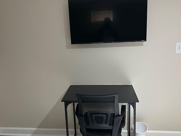 Designated work nook with a desk and office chair, plus a wall-mounted TV for added convenience.