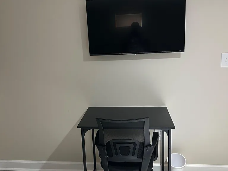 Designated work nook with a desk and office chair, plus a wall-mounted TV for added convenience.