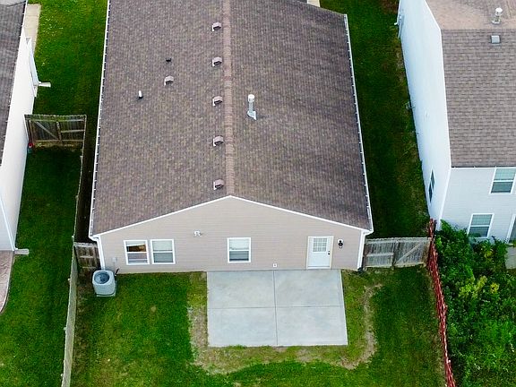 Private fenced in backyard with large concrete patio.