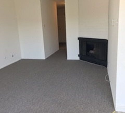 View of the living room with gas fireplace towards the hallway.