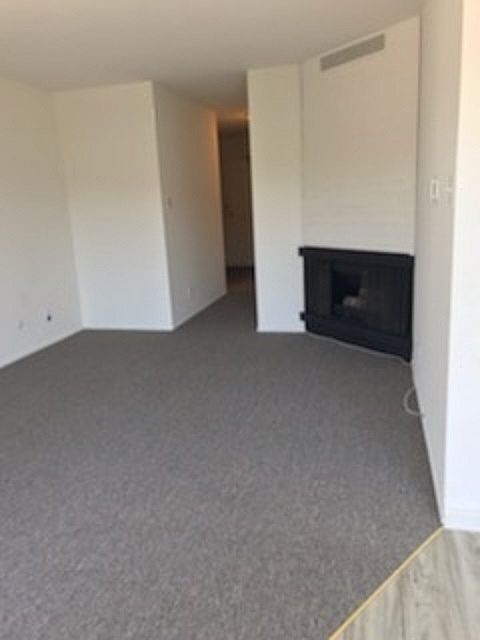 View of the living room with gas fireplace towards the hallway.