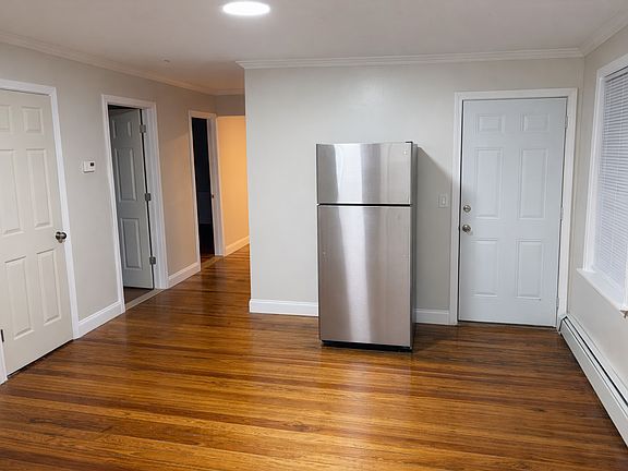 Dining area. Second entrance next to new stainless steel refrigerator. Doors leading to 2/3 bedrooms & closet.
