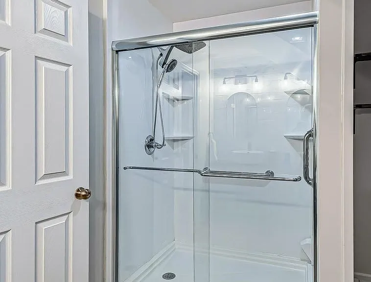 Low step-in shower with grab bar and rainfall shower head
