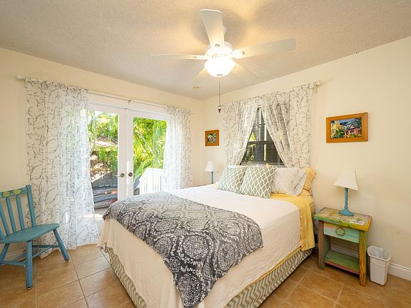 second bedroom with large closet space and french doors opening to pool deck and backyard