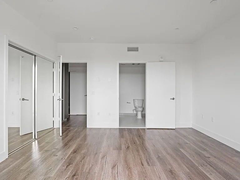Bedroom with Mirrored Closet, Vinyl Flooring, and Bathroom