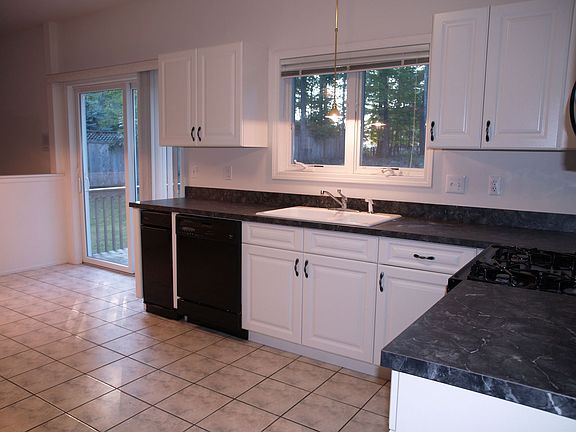 Spacious kitchen with lots of cabinet space and tiled floor