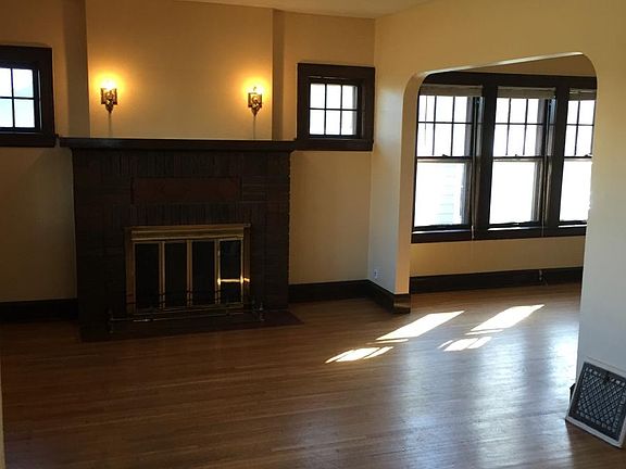 Living room surrounded by natural light. That fireplace does not work.
