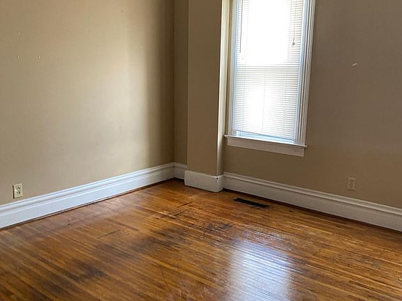 Living room with large double windows for plenty of light. Living room has decorative fireplace with bookcase.