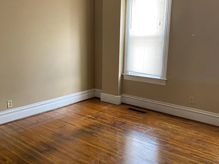 Living room with large double windows for plenty of light. Living room has decorative fireplace with bookcase.