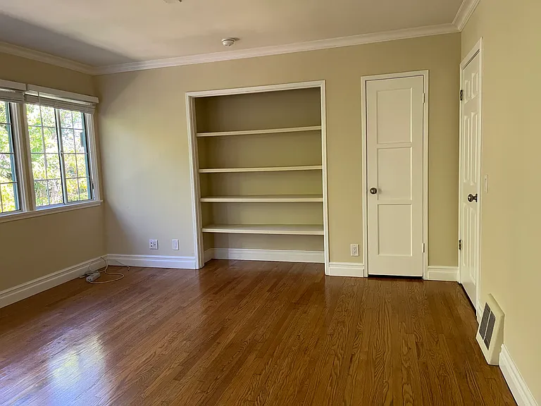 MAIN ROOM W/ HARDWOOD FLOORS & LARGE BOOKSHELVES