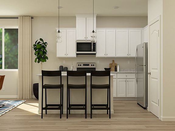 The kitchen has stainless steel appliances and plank flooring.