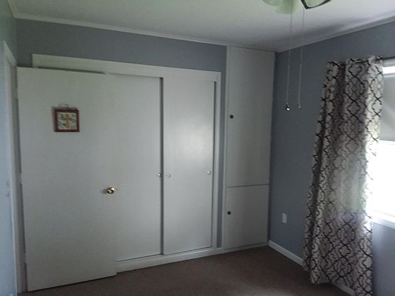 Bedroom is small with a built in dresser in the wall.
