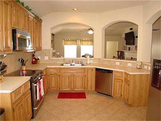 What a nice open kitchen. The arches over the breakfast bar lead into the family room. The cabinets are solid wood.