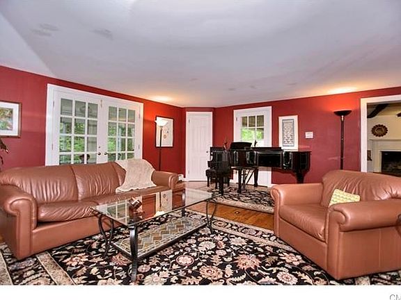 The Living room features one of 4 fireplaces in the house. French doors lead to Sun porch.