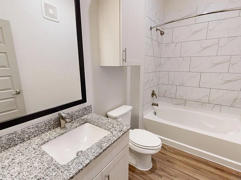 Apartment Bathroom with large soaking tub and Wood Style Flooring.