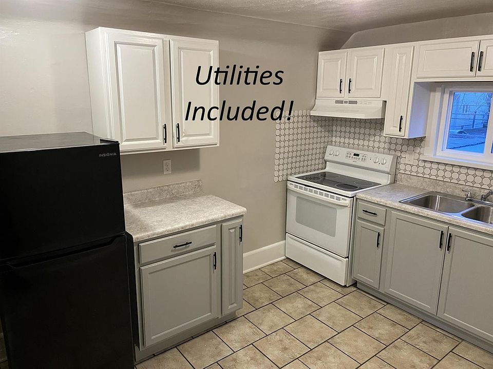 Recently remodeled kitchen with electric stove, fridge, lots of cabinet space and tiled backsplash.