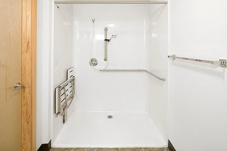 The ADA unit has a roll in shower with a fold down seat.