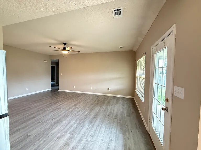 Another angle of the expansive living area showing the excellent flow, fresh paint, and direct access to the yard.