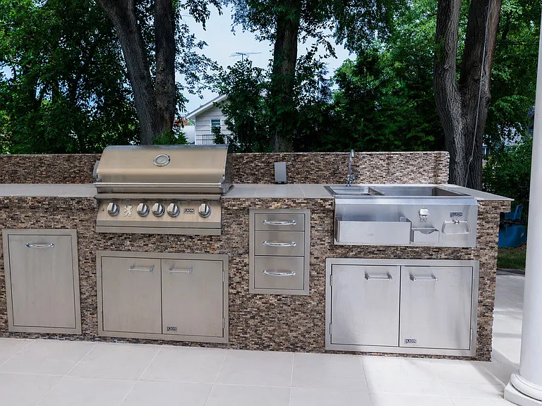 Outdoor kitchen featuring a built-in grill and sink!