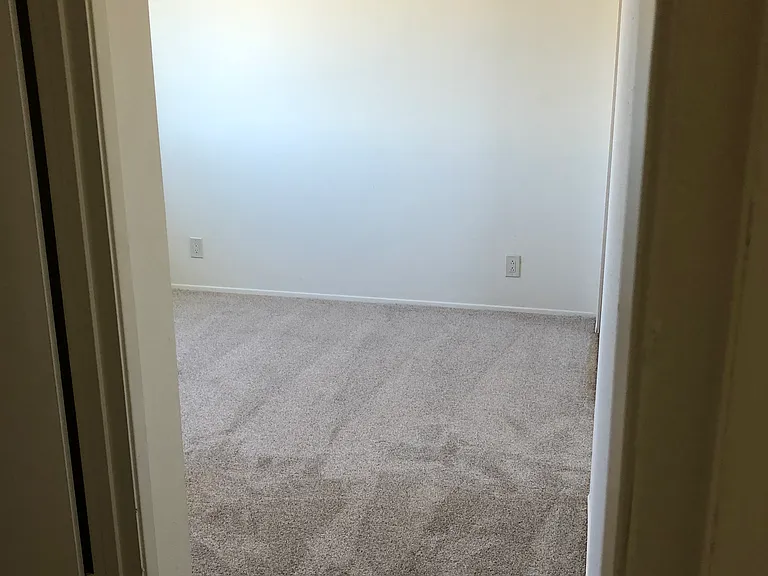 Second bedroom showing doorway to full bathroom.