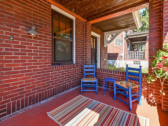 The unit features a covered front porch with a swing, which serves as an extension of the living space and sets the tone immediately upon arrival. With mature trees and an elevated outlook, the porch genuinely feels like you're sitting in a treehouse.